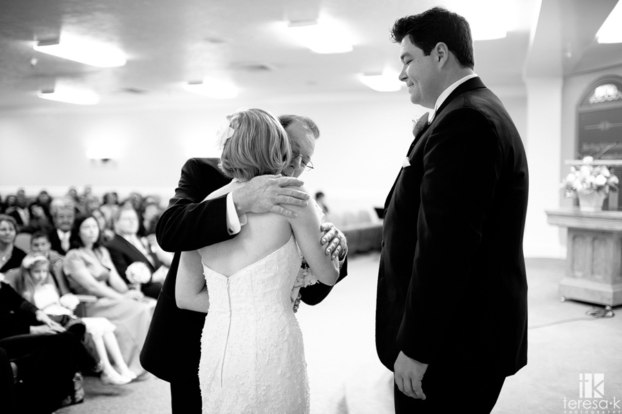 father hugs little girl goodbye at wedding ceremony