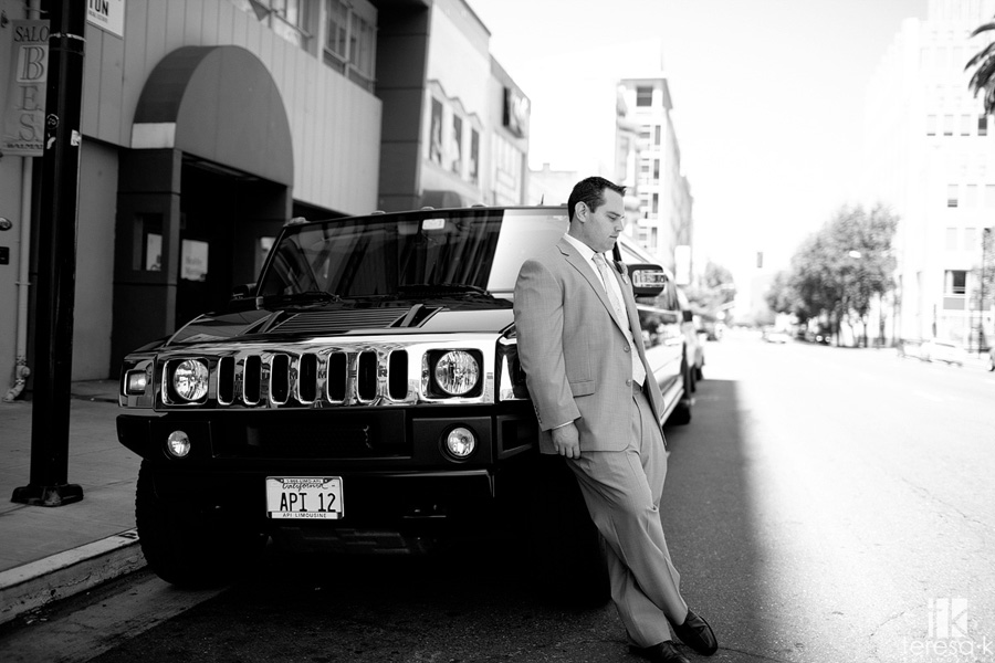 groom poses by the limo for Sacramento wedding