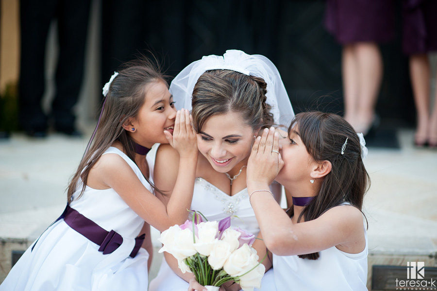 bride hearing a secret from flower girls