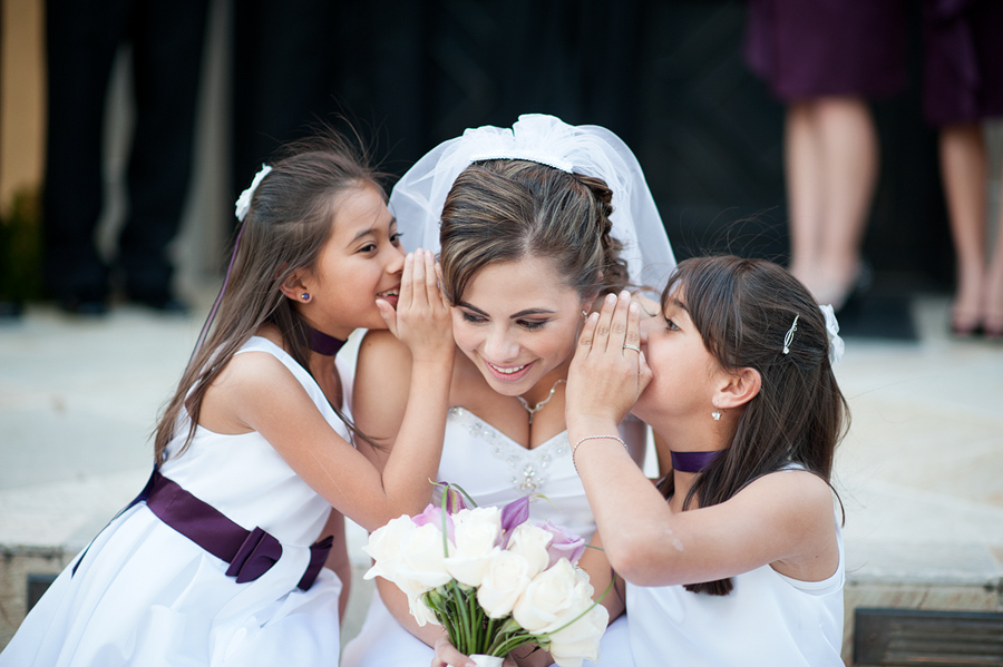 bride telling secrets to flower girls
