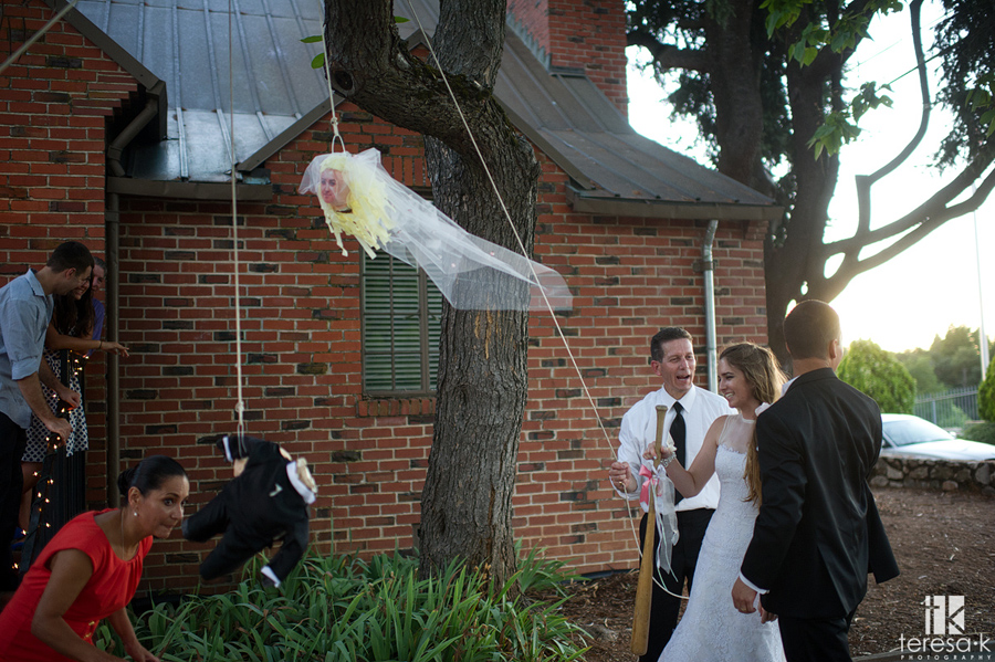 bride and groom hit piñatas at wedding reception