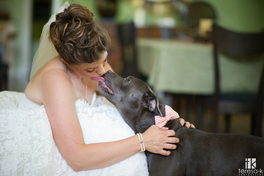 bride giving doggy a kiss before wedding